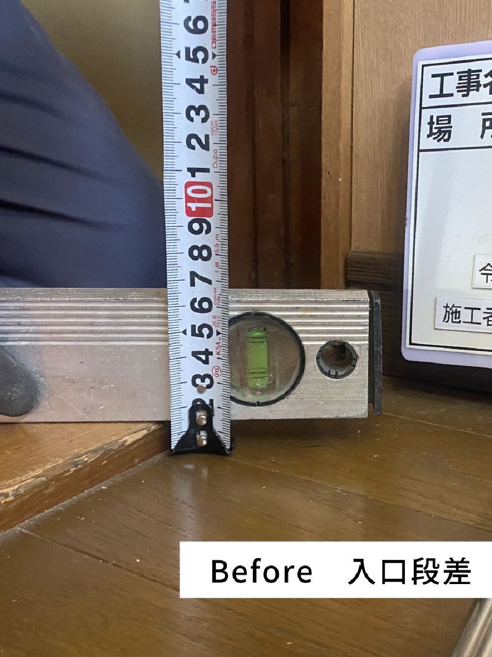 岐阜市S様邸の洗面所リフォームにおける段差解消工事のBefore写真（廊下と洗面所の床段差を計測中）